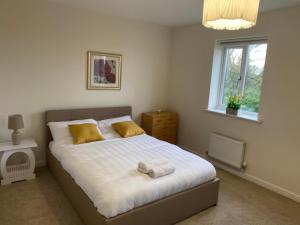 伍尔弗汉普顿Beautiful Home in Wolverhampton!的一间卧室配有一张带黄色枕头的床和一扇窗户