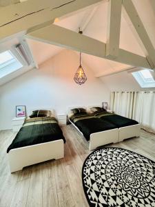 拉纳肯Stylish Home near Maastricht Alicias house的阁楼卧室设有两张床和天窗。