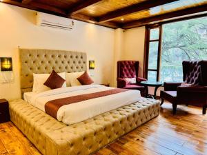 卡索尔The Kasol Parvati View by - ASIA HOLIDAYS的一间卧室配有一张大床和一个大簇绒床头板