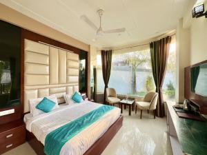 瑞诗凯诗Sumedha Resort & SPA Rishikesh的一间卧室配有一张大床和电视