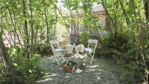 OrtonovoCasale Amati Country House的树木繁茂的花园中的桌椅