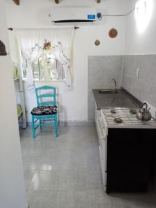 特尔马斯德里奥翁多Cabaña el rincón de Termas的厨房配有蓝色椅子和水槽
