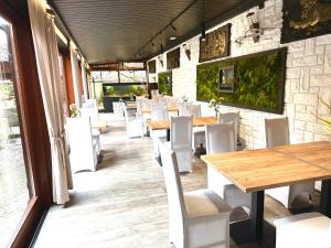 文盖尔斯卡－古尔卡Pensjonat Melaxa的配有木桌和白色椅子的餐厅