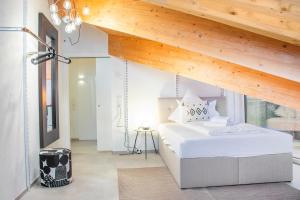 伊兹林根※Luxus Loft mit Boxspringbetten und Heimkino ※的卧室设有白色的床和木制天花板。