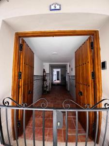 马拉加Shanti’s Andalusian Rooms的房屋内带木门的走廊