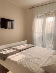 蒂瓦特M&N Residence Tivat的白色的卧室设有床和窗户