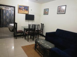 拉合尔Two Bedrooms Apartment Near DHA & Airport的客厅配有沙发和桌椅