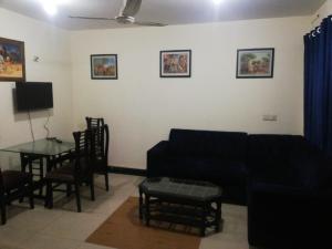 拉合尔Two Bedrooms Apartment Near DHA & Airport的客厅配有沙发和桌子