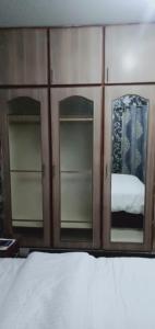 拉合尔Two Bedrooms Apartment Near DHA & Airport的木柜,配有两面镜子和一张床