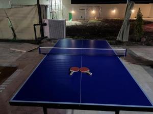 安曼Giving Paradise Chalet的一张乒乓球桌,上面有两根乒乓球拍