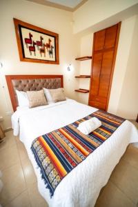 奥塔瓦洛tourist house suites 2的一间卧室配有一张大床和色彩缤纷的毯子