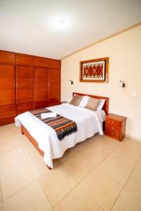 奥塔瓦洛tourist house suites 2的一间卧室配有一张大床和木制橱柜。