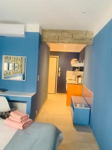 塞萨洛尼基Petrus Studio with balcony的卧室拥有蓝色和橙色的墙壁,配有一张床