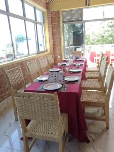 RubavuKivu Summer Hotel的用餐室配有带紫色桌布的长桌