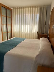 佩尼斯科拉瑞虎佩佩酒店的卧室设有一张白色大床和一扇窗户。