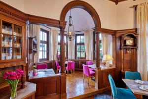 加尔米施-帕滕基兴艾森尼酒店的用餐室配有粉红色的椅子和桌子
