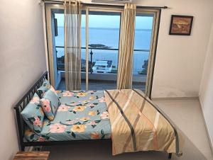 莫尔穆冈2 BHK SKY water Apartment(SKY 2)的一间卧室设有一张床,享有海景