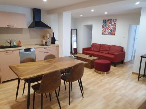 Mareuil-sur-AyLa Cour des Marotiers的客厅配有桌子和红色沙发