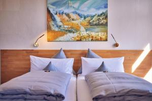 加尔米施-帕滕基兴艾森尼酒店的床上的2个枕头,墙上有绘画作品