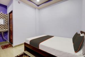 古瓦哈提Super Collection O Ashirbad Lodge的一间卧室配有一张床和一张书桌