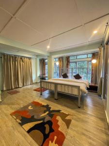 麦罗肯机Eevolve Dharamkot - An Eco Hostel的一间卧室设有一张床和一个大窗户