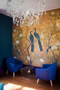 CahonLe Jardin, chambres d'hôtes en Baie de Somme的墙上的鸟儿画画,有两把蓝色椅子