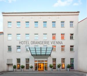 维也纳Hotel Orangerie的白色的建筑,上面有读酒店或城市景观的标志