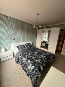 布利安什维莱La Terasse des Vignes - Maison 2 Chambres - 4 Personnes的一间卧室配有一张带黑色毯子和镜子的床