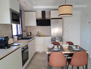 莫哈卡尔roomwithview casa marco的厨房配有白色橱柜和桌椅