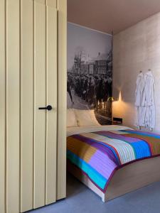 多克姆Stadslogement Het Keerpunt Dokkum的卧室配有一张床,墙上挂有绘画作品
