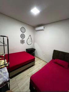 多拉杜斯JOTA Área de Lazer的一间卧室配有两张床和红色的床罩