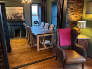LeverburghKilda House的一间带桌椅和壁炉的用餐室