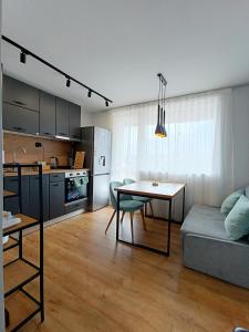 SilistraКокетен апартамент VeRa Suite的厨房以及带桌子和沙发的客厅。