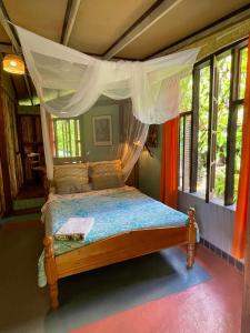 罗索Cocoa Cottage的一间卧室配有一张带天蓬的床