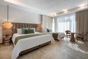 卡塔赫纳Oz Hotel Cartagena的酒店客房设有两张床和一张桌子。