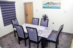 EgbaCozy Urban Oasis 3 Bedroom in Ogba, Ikeja, Lagos的一间带桌子和四把椅子的用餐室