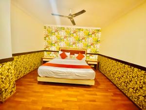海得拉巴The City Park hotel的卧室配有一张床,墙上挂有绘画作品