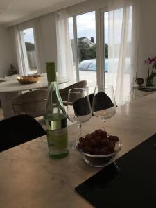 哈尔姆斯塔德Stan- och strandnära poolvilla.的一张桌子,上面放着两杯酒和一碗葡萄