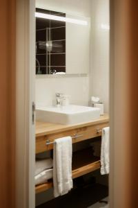 尚特洛普恩布里Hôtel Dali Val d'Europe的浴室配有盥洗盆、镜子和毛巾
