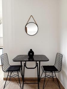 巴尔Danin apartmani的一张桌子、两把椅子和一面墙上的镜子