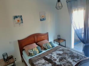 滨海萨纳里BORD DE PLAGE LÔNES BONNEGRACE, PORT de SANARY SUR MER的卧室配有带枕头的床铺和窗户。