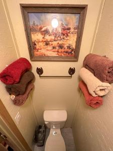 坎顿Acorn Hideaways Canton Old Western Ranch Hands' Suite的浴室提供毛巾,卫生间上方设有一幅画