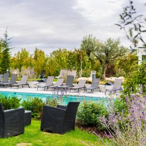 尚特洛普恩布里Hôtel Dali Val d'Europe的一个带椅子的庭院和一个游泳池