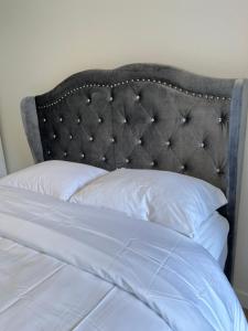 帕罗奥多One room with one queen bed studio to rent的一张带黑色床头板和白色枕头的床
