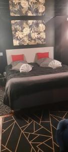 Feigèresappartement cosy的一间卧室配有一张带红色枕头的大床