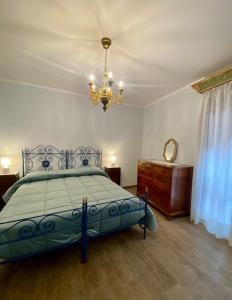 古比奥Casa Vacanze Il Borgo的一间卧室配有蓝色的床和吊灯。
