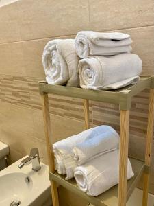 古比奥Casa Vacanze Il Borgo的浴室架子上的一大堆毛巾