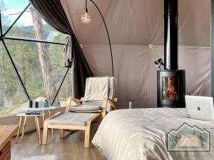拉纳卡Dome in Nature的一间卧室设有一张床铺和一个壁炉的帐篷
