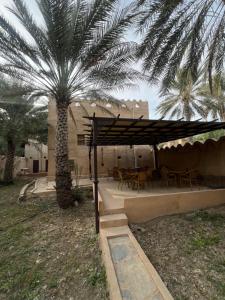 阿尔哈姆拉Mall Aldakhil House的一个带棕榈树和桌椅的庭院
