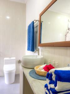 NilandhooHide Inn Blue的一间带水槽和一篮毛巾的浴室